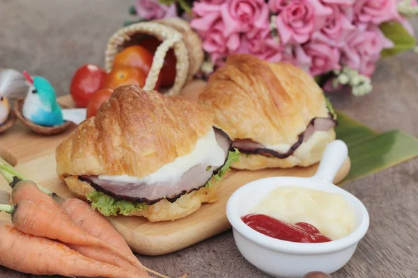 Croissant-Sandwich mit gegrilltem Schweinefleisch, Gemüse und Käse. — Stockfoto