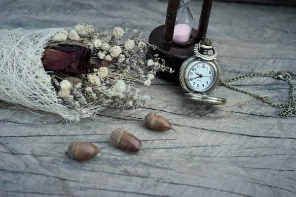 Reloj de bolsillo antiguo y reloj de arena con flores secas . — Foto de Stock