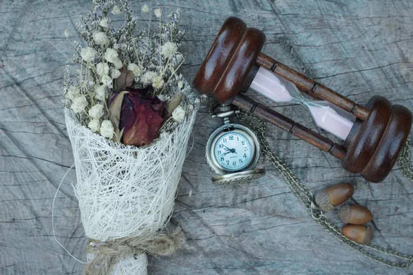 Reloj de bolsillo antiguo y reloj de arena con flores secas . — Foto de Stock