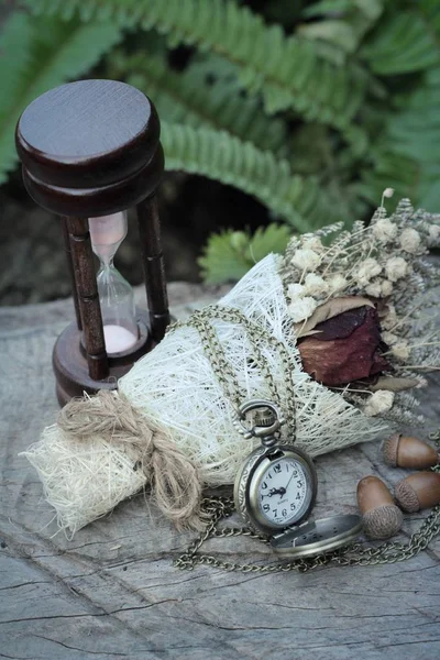Starožitné kapesní hodinky a přesýpací hodiny s sušených květin. — Stock fotografie