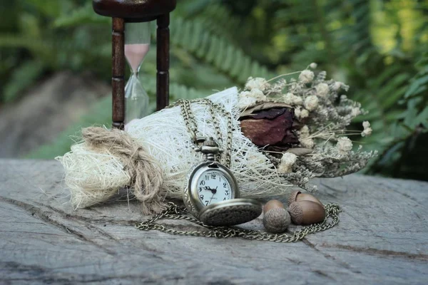 Reloj de bolsillo antiguo y reloj de arena con flores secas . — Foto de Stock