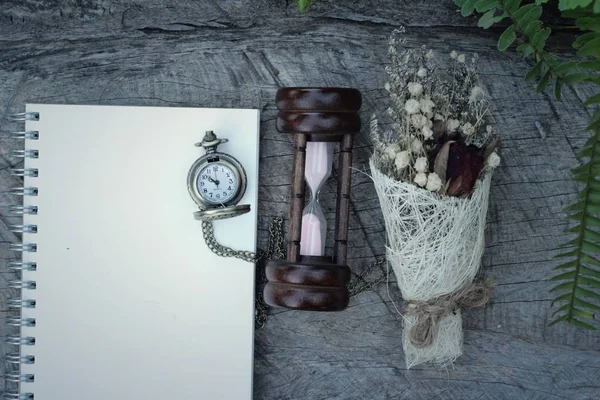 Reloj de bolsillo antiguo y reloj de arena con flores secas . — Foto de Stock