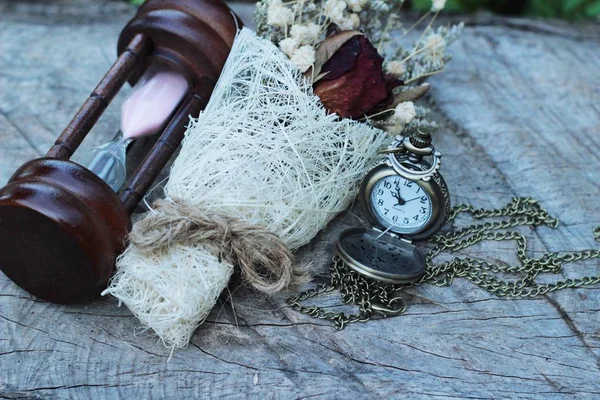 Reloj de bolsillo antiguo y reloj de arena con flores secas . — Foto de Stock