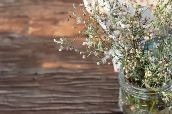 Bloemen in een vaas op houten achtergrond. — Stockfoto