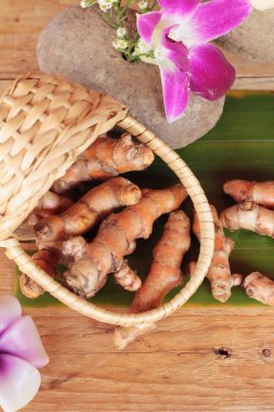 Zerdeçal kök ahşap arka plan üzerinde zerdeçal tozu ile