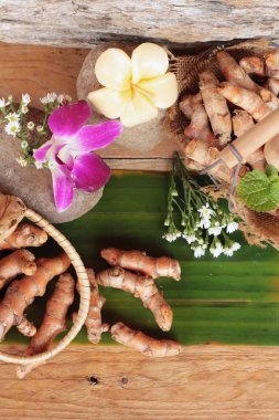 Zerdeçal kök ahşap arka plan üzerinde zerdeçal tozu ile