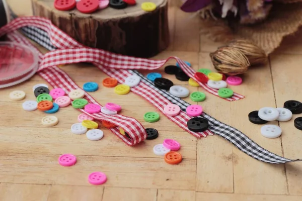 Botones de plástico coloridos para coser sobre fondo de madera —  Fotos de Stock