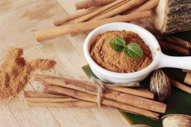 toz tarçın ve ahşap arka plan üzerinde sopa