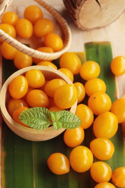 Ahşap arka plan üzerinde organik sarı domates