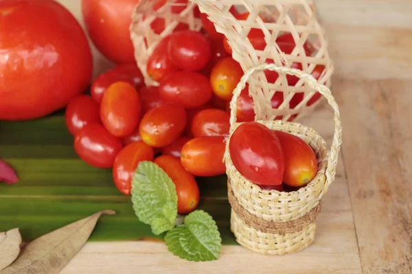 Tomates rojos frescos ecológicos sobre fondo de madera — Foto de Stock