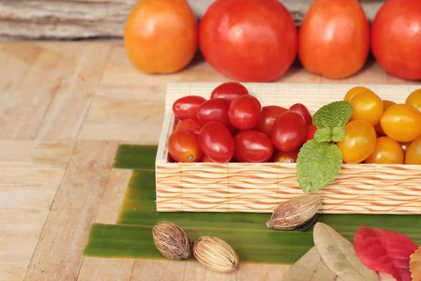 Tomates rojos y amarillos ecológicos sobre fondo de madera — Foto de Stock