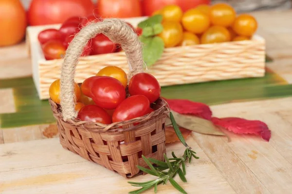 Tomates rojos y amarillos ecológicos sobre fondo de madera — Foto de Stock