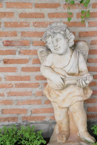 Standbeeld van Cupido is schoonheid in de tuin — Stockfoto