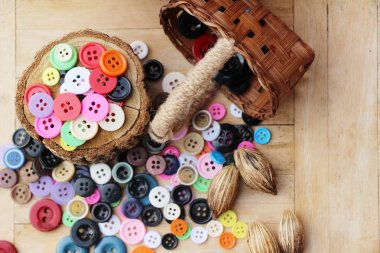 Dikiş ahşap arka plan üzerinde renkli plastik düğmeler