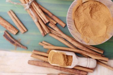 toz tarçın ve ahşap arka plan üzerinde sopa