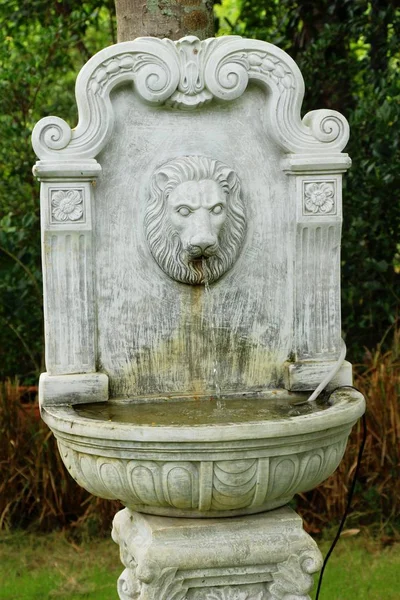 Lion statue spitting water vintage style in garden — Stock Photo, Image