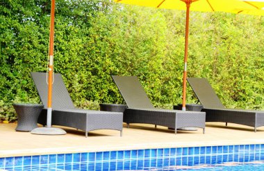 Havuz başında şemsiye ile rahat daybed