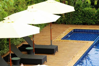 Havuz başında şemsiye ile rahat daybed