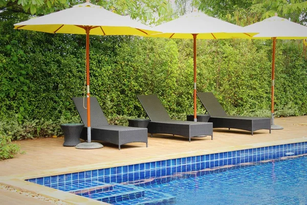 Havuz başında şemsiye ile rahat daybed