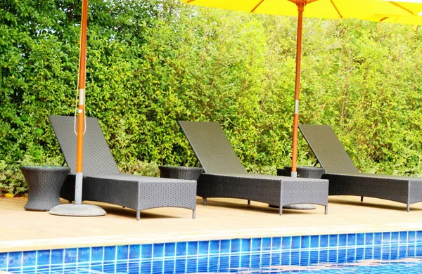 Havuz başında şemsiye ile rahat daybed