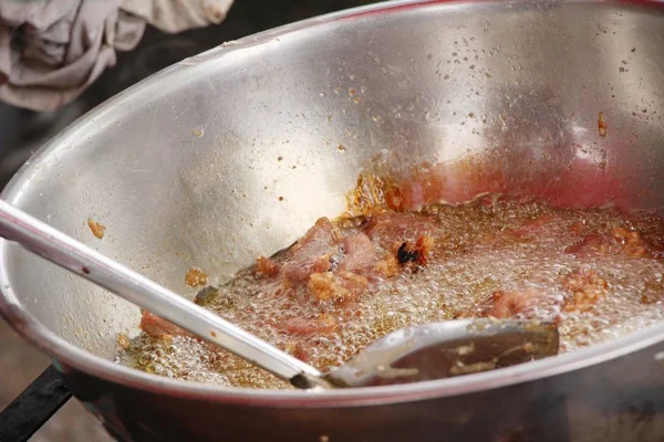 Smažené vepřové maso v pánvi v pouliční stánky s jídlem — Stock fotografie