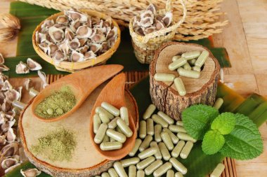 Ahşap arka plan üzerinde sağlık için Moringa kapsül