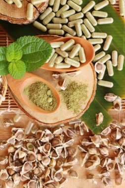 Ahşap arka plan üzerinde sağlık için Moringa kapsül