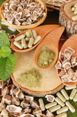 Ahşap arka plan üzerinde sağlık için Moringa kapsül