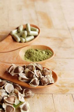 Ahşap arka plan üzerinde sağlık için Moringa kapsül