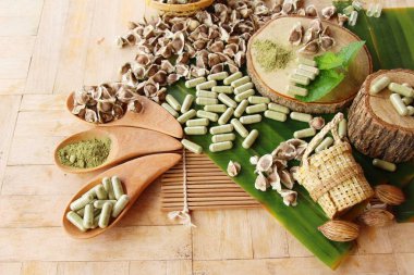 Ahşap arka plan üzerinde sağlık için Moringa kapsül