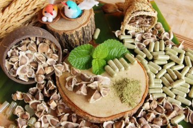 Ahşap arka plan üzerinde sağlık için Moringa kapsül