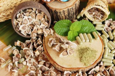 Ahşap arka plan üzerinde sağlık için Moringa kapsül