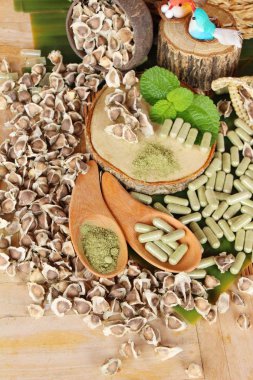 Ahşap arka plan üzerinde sağlık için Moringa kapsül