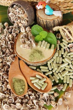 Ahşap arka plan üzerinde sağlık için Moringa kapsül