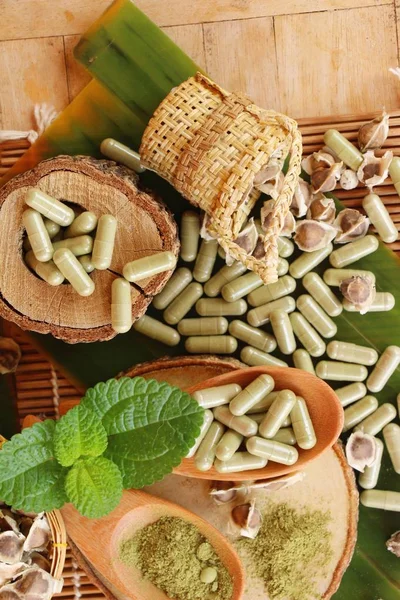 Ahşap arka plan üzerinde sağlık için Moringa kapsül