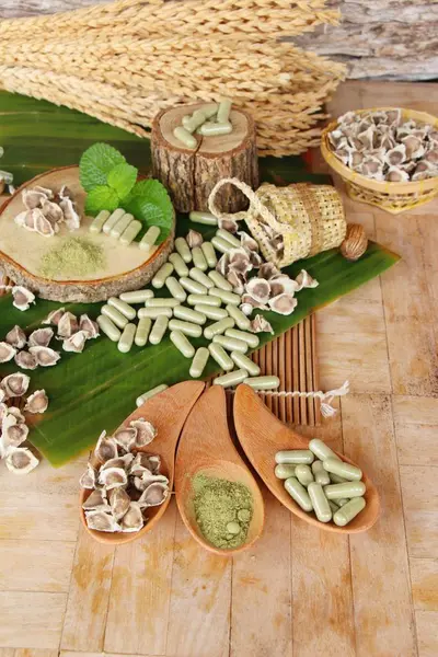 Capsula Moringa per la salute su fondo legno — Foto Stock