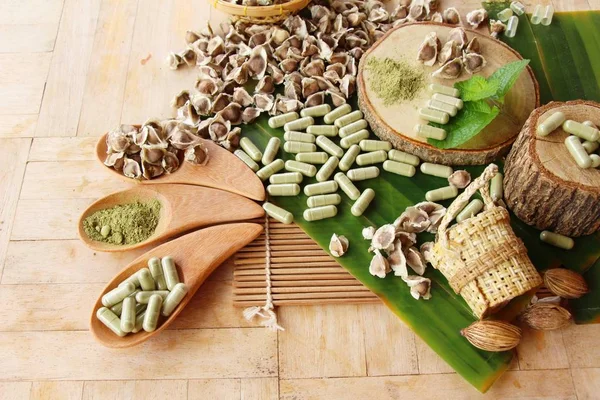 Ahşap arka plan üzerinde sağlık için Moringa kapsül