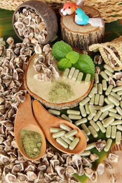 Ahşap arka plan üzerinde sağlık için Moringa kapsül