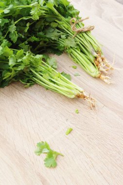 Ahşap arka plan üzerinde yemek için taze kişniş