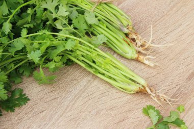 Ahşap arka plan üzerinde yemek için taze kişniş