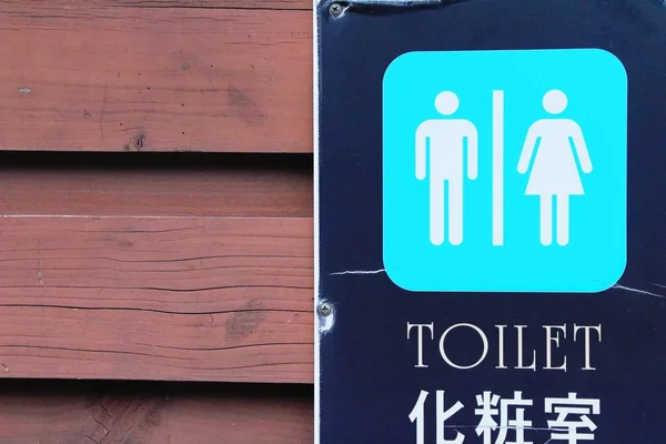 Символ стрелки указывая пойти в сторону туалета, Корея — стоковое фото