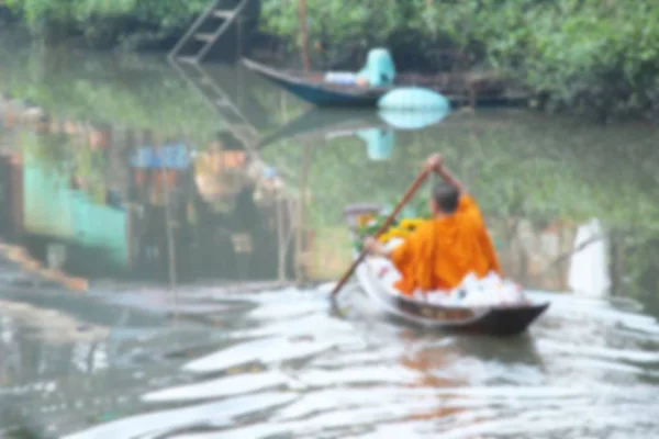 Suddig buddhistmunk i roddbåt vid floden — Stockfoto