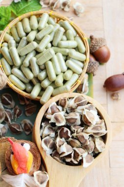 Ahşap arka plan üzerinde sağlık için Moringa kapsül