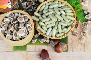 Ahşap arka plan üzerinde sağlık için Moringa kapsül