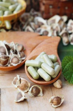 Ahşap arka plan üzerinde sağlık için Moringa kapsül