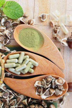 Ahşap arka plan üzerinde sağlık için Moringa kapsül