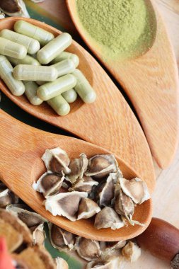 Ahşap arka plan üzerinde sağlık için Moringa kapsül