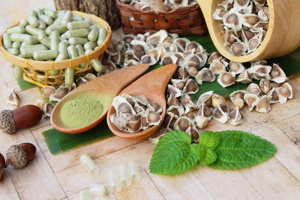 Ahşap arka plan üzerinde sağlık için Moringa kapsül