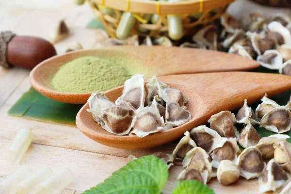 Ahşap arka plan üzerinde sağlık için Moringa kapsül