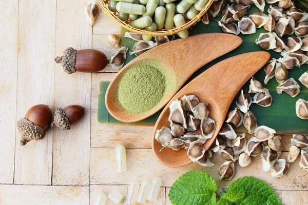 Ahşap arka plan üzerinde sağlık için Moringa kapsül